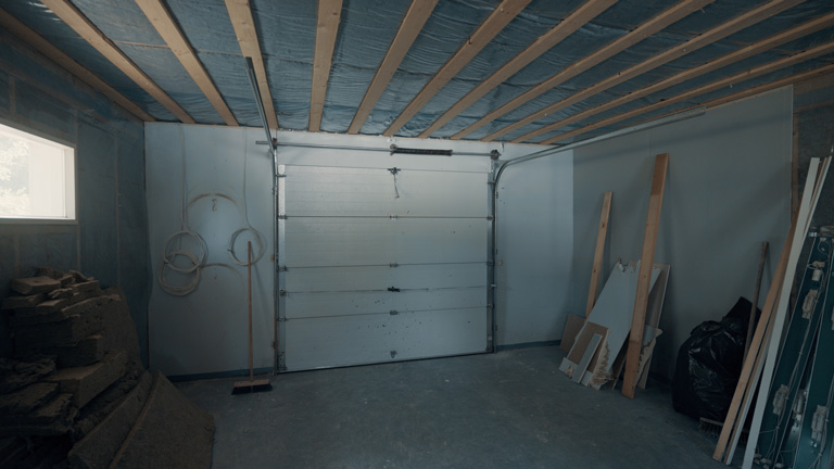 Bare garage space before the studio build began, showing the original garage